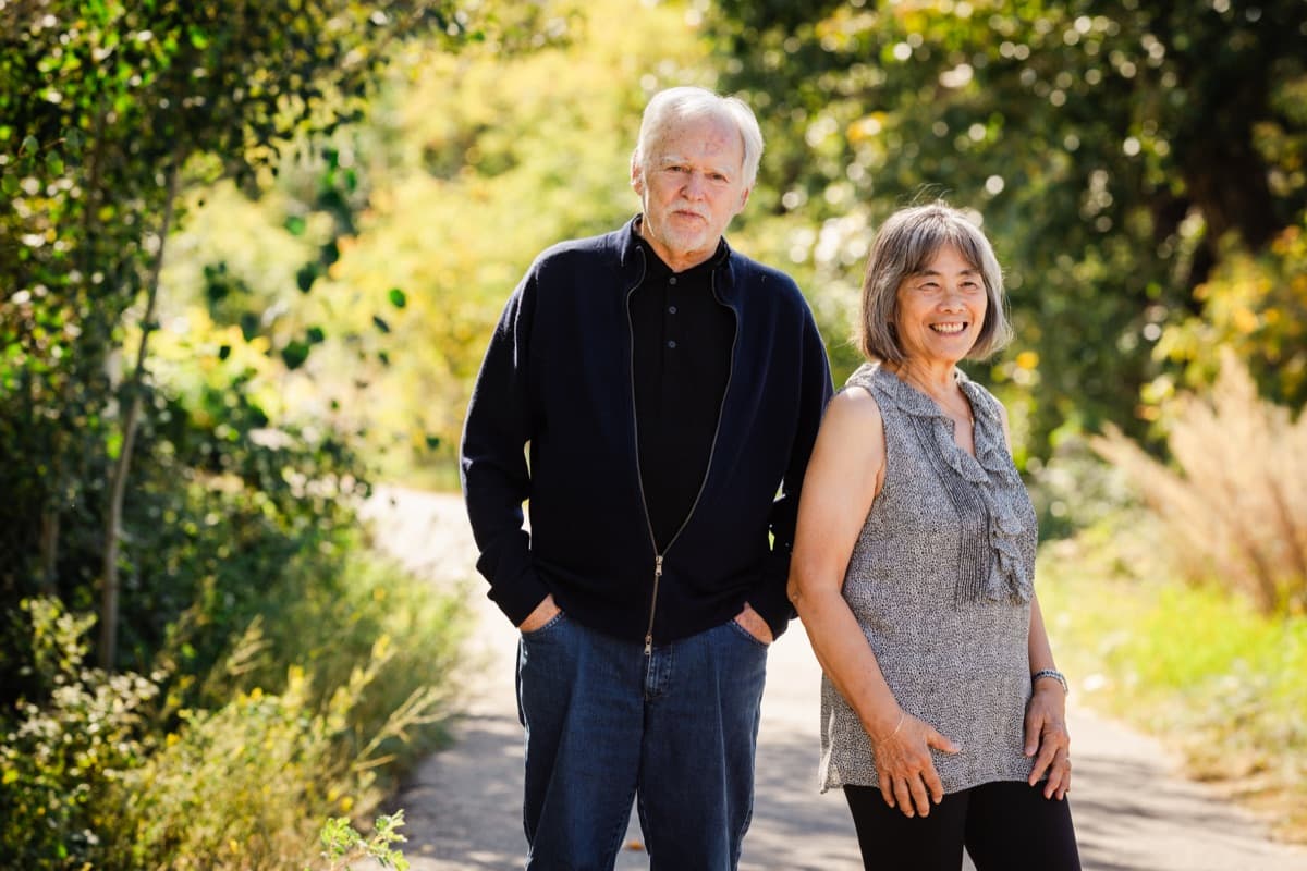 Nick and Madeline walking on a tree-lined path